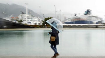 Una mujer paseando bajo la lluvia