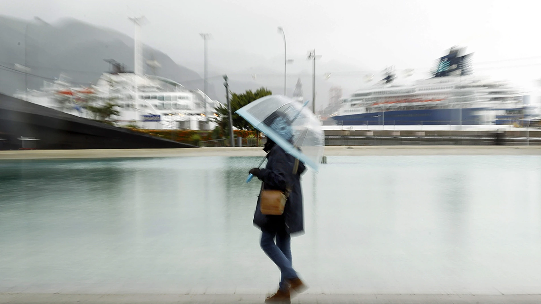 Una mujer paseando bajo la lluvia Una mujer paseando bajo la lluvia