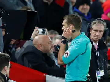 Un colegiado recurre al videoarbitraje y consulta el VAR durante un partido de la Premier Un colegiado recurre al videoarbitraje y consulta el VAR durante un partido de la Premier