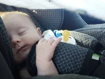 Un bebé en una sillita de coche Un bebé en una sillita de coche