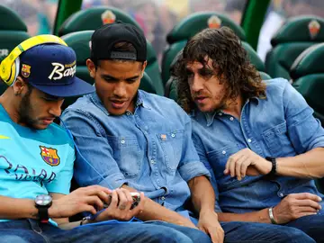 Neymar enseña su móvil a Jonathan dos Santos y a Puyol Neymar enseña su móvil a Jonathan dos Santos y a Puyol