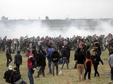 Palestinos huyen de gases lacrimógenos durante los enfrentamientos con soldados israelíes Palestinos huyen de gases lacrimógenos durante los enfrentamientos con soldados israelíes