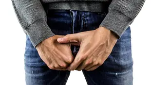 Un hombre se toca sus genitales Un hombre se toca sus genitales