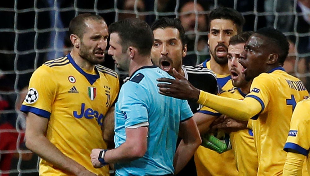 El colegiado Michael Oliver, acosado por los jugadores de la Juventus