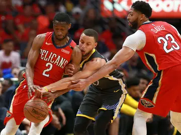 Curry intenta robar el balón entre Holiday y Davis Curry intenta robar el balón entre Holiday y Davis