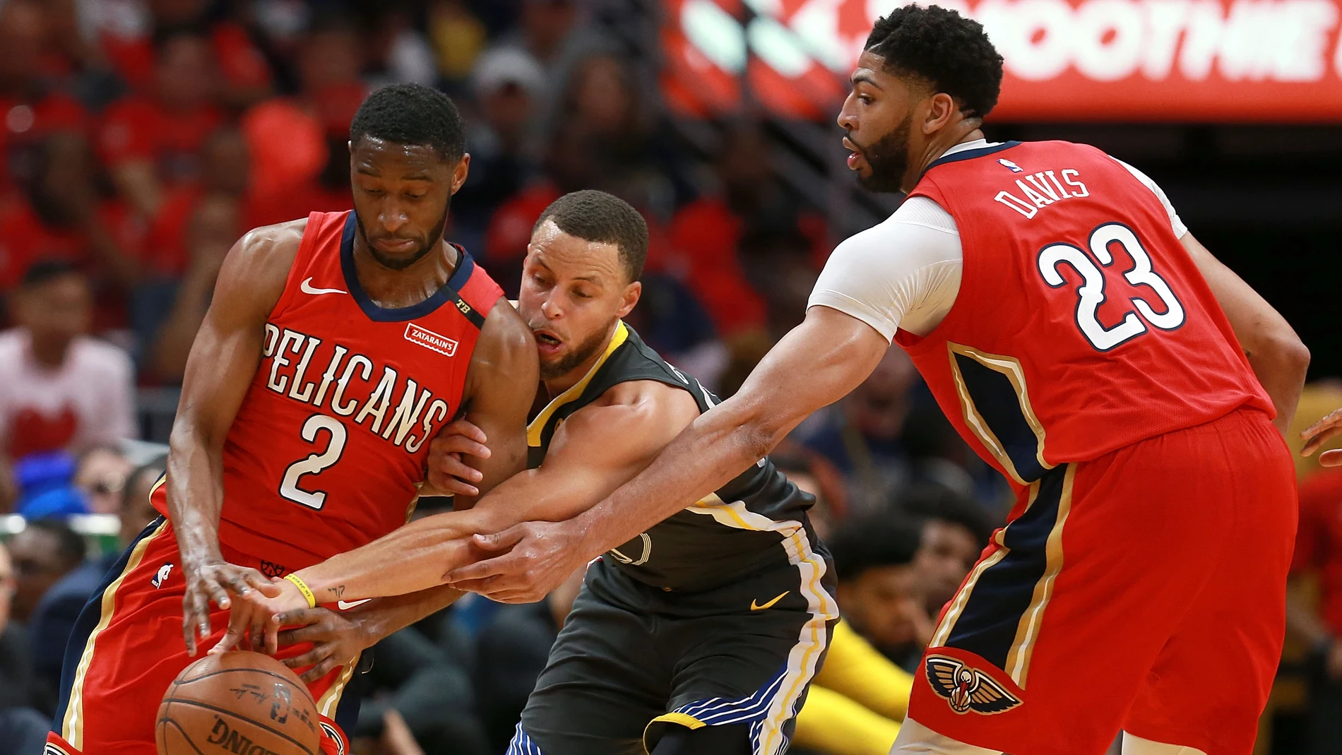 Curry intenta robar el balón entre Holiday y Davis Curry intenta robar el balón entre Holiday y Davis