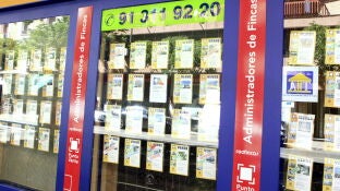 Imagen de archivo de un escaparate de una inmobiliaria en Barcelona, con anuncios de pisos en venta