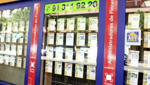 Imagen de archivo de un escaparate de una inmobiliaria en Barcelona, con anuncios de pisos en venta