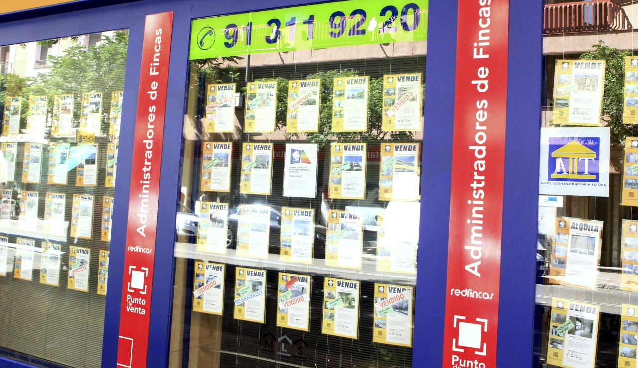Imagen de archivo de un escaparate de una inmobiliaria en Barcelona, con anuncios de pisos en venta