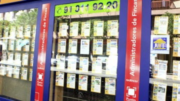 Imagen de archivo de un escaparate de una inmobiliaria en Barcelona, con anuncios de pisos en venta