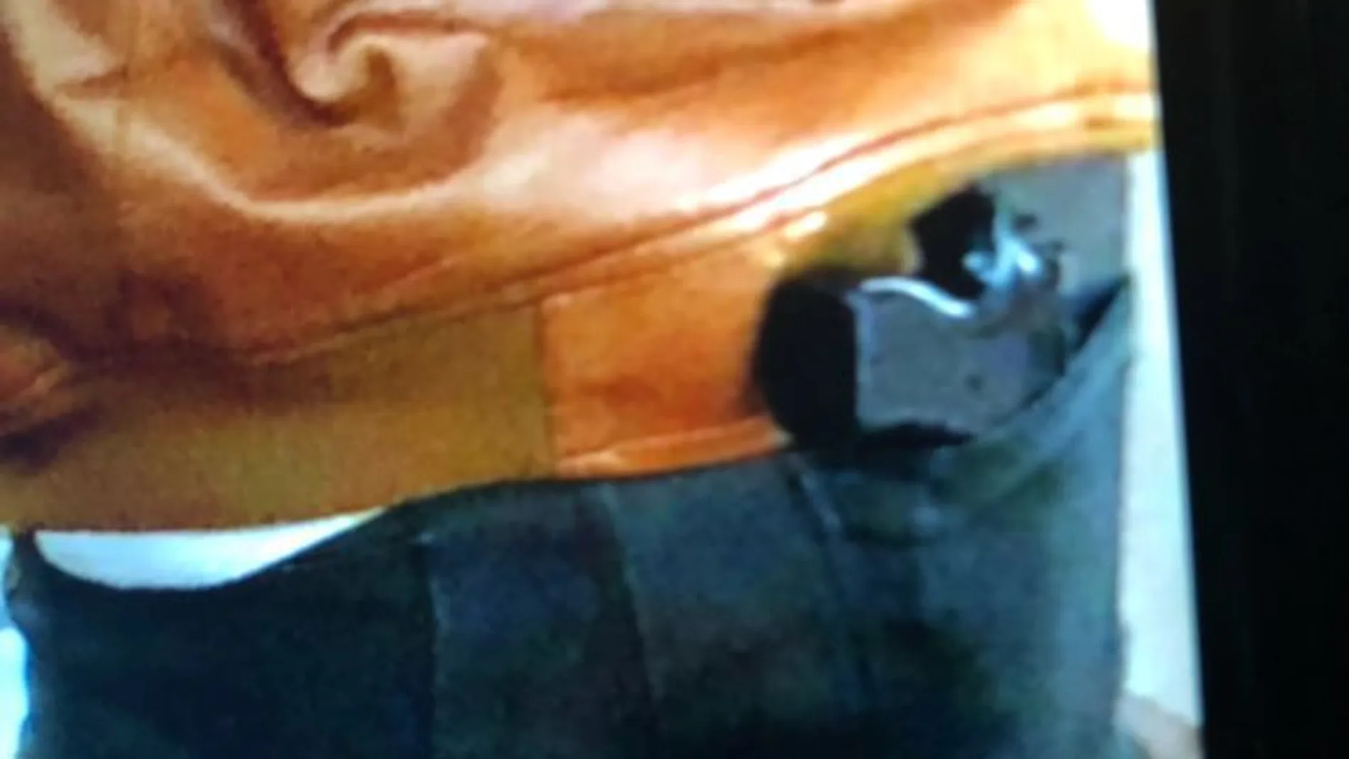La imagen del individuo con la funda con forma de pistola La imagen del individuo con la funda con forma de pistola