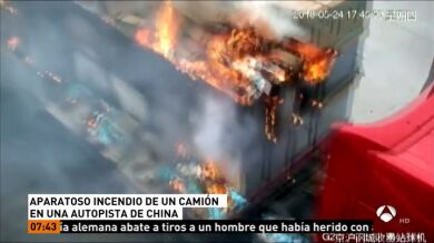 Un conductor trata de sofocar un incendio en su camión en medio de una autopista de China