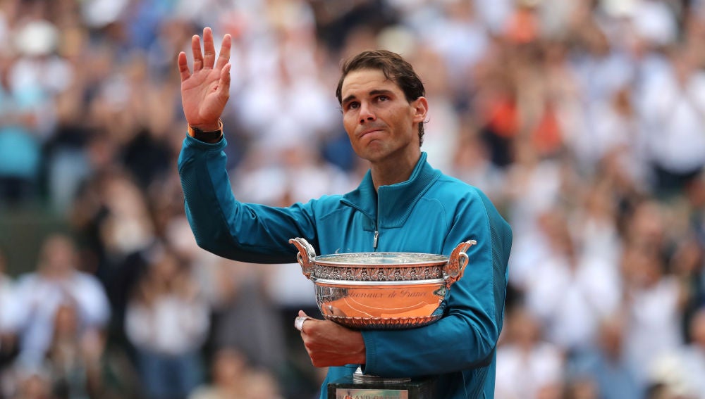 Rafa Nadal saluda al público con el trofeo de Roland Garros