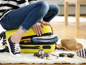 Mujer cerrando maleta Mujer cerrando maleta