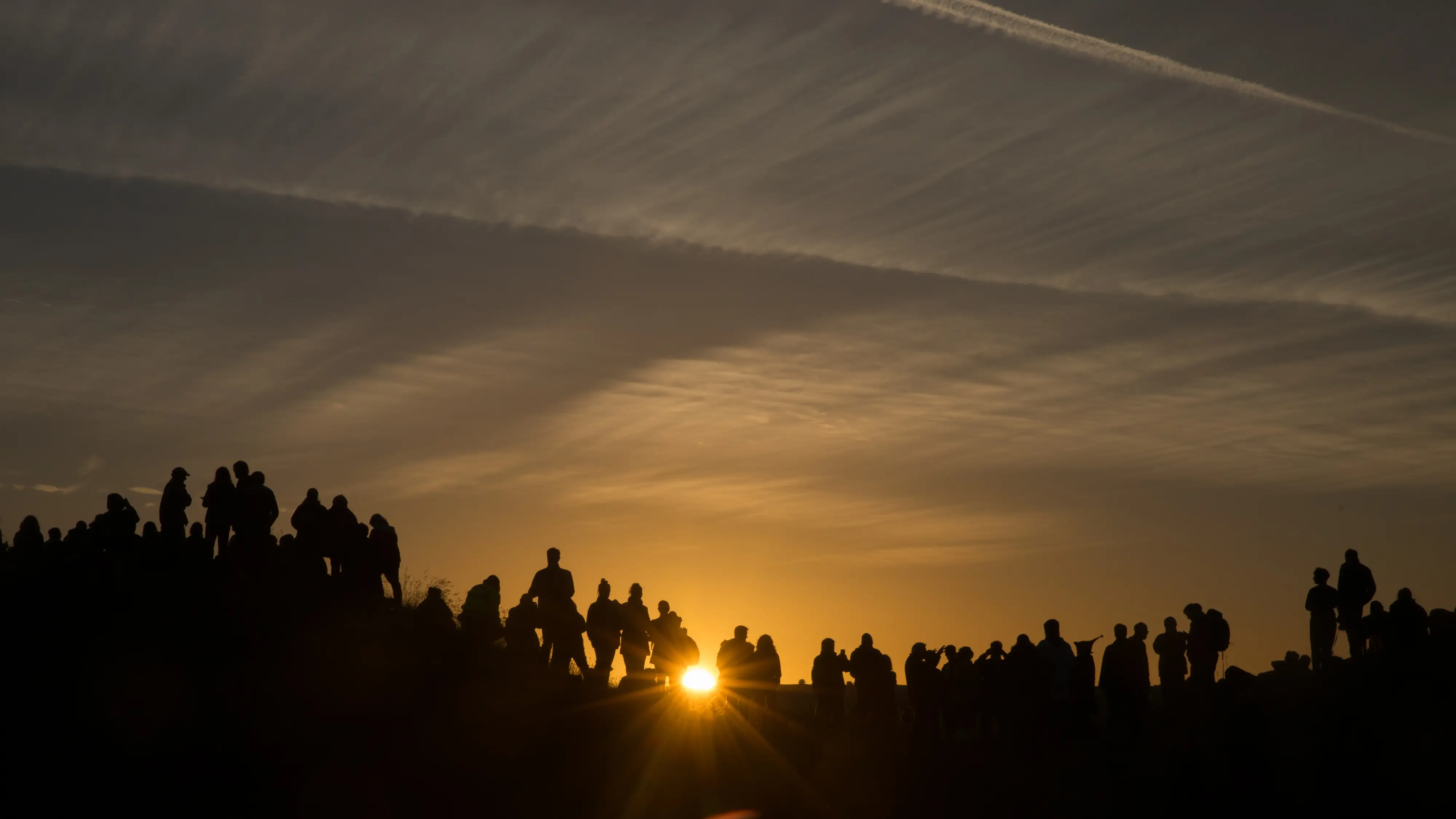 La gente se re&uacute;ne en la cresta que domina el monumento henge del neol&iacute;tico de Avebury, declarado Patrimonio de la Humanidad por la UNESCO, mientras esperan a que salga el sol.