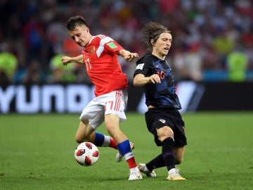 Golovin y Modric disputan la posesión del balón
