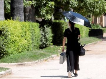 Una mujer se protege con un parasol 