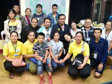 El primer ministro tailandés, Prayut Chan-o-cha, posa junto a familiares de los niños rescatados