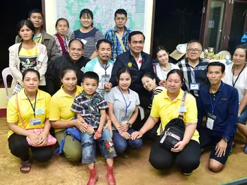 El primer ministro tailandés, Prayut Chan-o-cha, posa junto a familiares de los niños rescatados El primer ministro tailandés, Prayut Chan-o-cha, posa junto a familiares de los niños rescatados