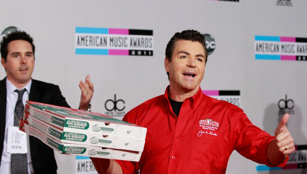 John Schnatter con pizzas de la compañía