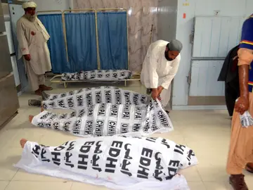 Un hombre cubre los cuerpos de las víctimas del atentado bomba Un hombre cubre los cuerpos de las víctimas del atentado bomba
