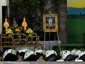 Los doce niños y su entrenador rescatados del interior de una cueva en el norte de Tailandia muestran sus respetos ante un retrato del rey de Tailandia