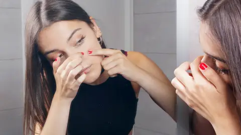 Chica quitándose puntos negros Chica quitándose puntos negros