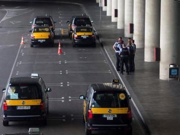 Un grupo de taxistas permanecen parados con sus vehículos en el Aeropuerto de Barcelona