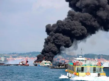Columna de humo negro provocada por el incendio de un catamarán turístico. Columna de humo negro provocada por el incendio de un catamarán turístico.