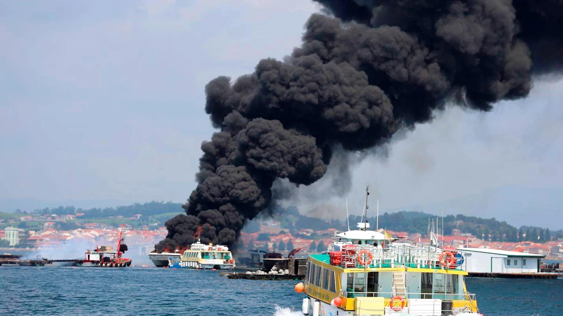 Columna de humo negro provocada por el incendio de un catamarán turístico. Columna de humo negro provocada por el incendio de un catamarán turístico.
