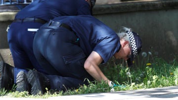 Policías británicos buscando pruebas sobre la escena de un crimen