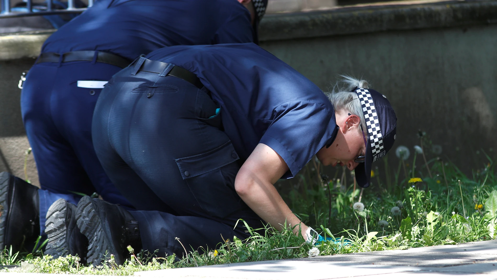 Policías británicos buscando pruebas sobre la escena de un crimen Policías británicos buscando pruebas sobre la escena de un crimen