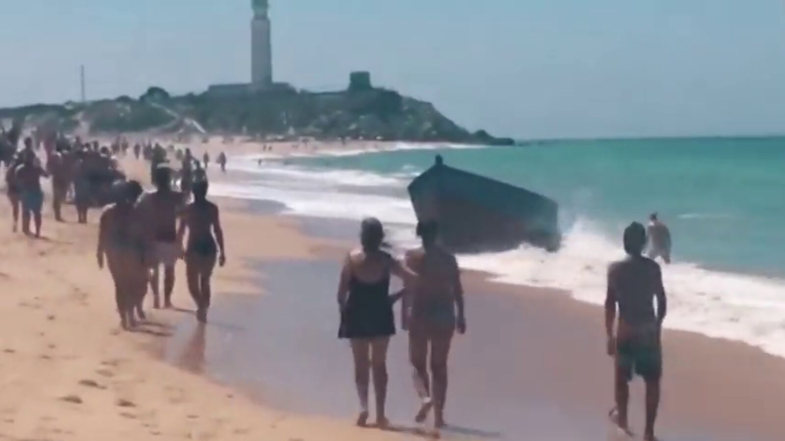 Varias decenas de jóvenes llegan en patera a la playa de Zahora ante la mirada atenta de los bañistas