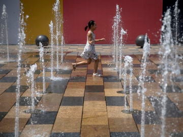 A child plays in a fountain in the Sanlitun area of Beijing, China