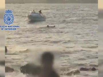 Un policía rescata a un migrante que saltó al mar en la bahía de Algeciras