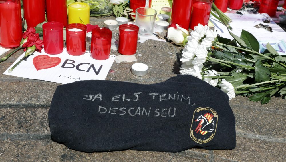 Detalle de una camiseta de la Brigada Móvil de los Mossos d'Esquadra con la frase "Ya los tenemos. Descansad"