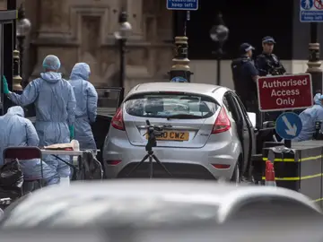 Oficiales forenses examinan el coche que chocó contra las barreras del Parlamento británico Oficiales forenses examinan el coche que chocó contra las barreras del Parlamento británico