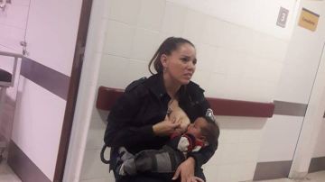 La policía dando el pecho al bebé