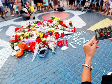 Una turista fotografía los ramos de flores y objetos de todo tipo depositados Una turista fotografía los ramos de flores y objetos de todo tipo depositados