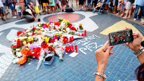 Una turista fotografía los ramos de flores y objetos de todo tipo depositados Una turista fotografía los ramos de flores y objetos de todo tipo depositados