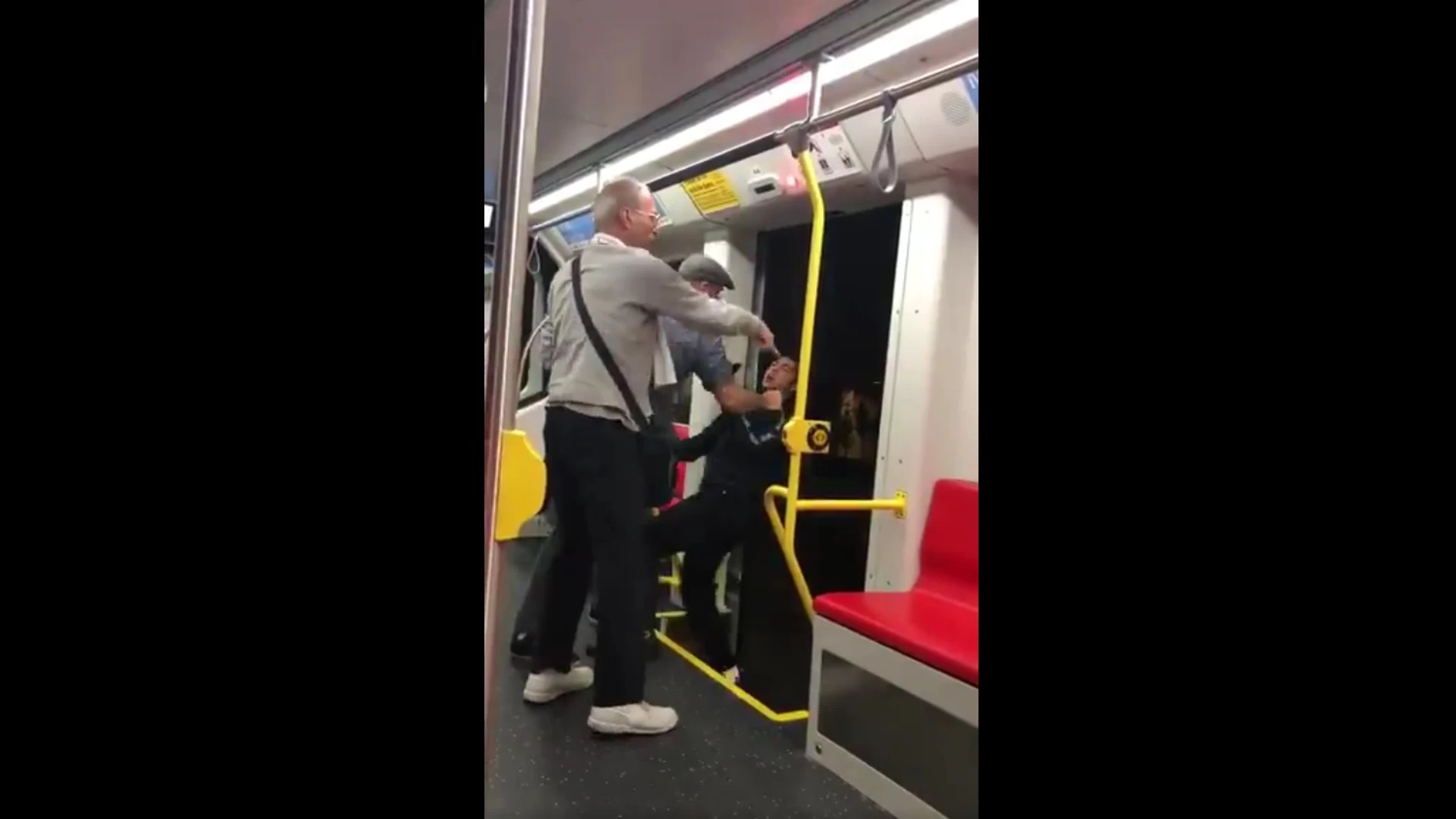 Los dos hombres intentando arrojar al joven Los dos hombres intentando arrojar al joven
