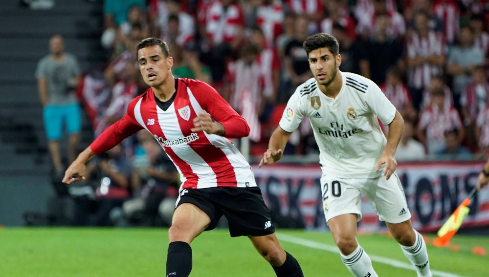 Dani García conduce el balón ante la presión de Marco Asensio
