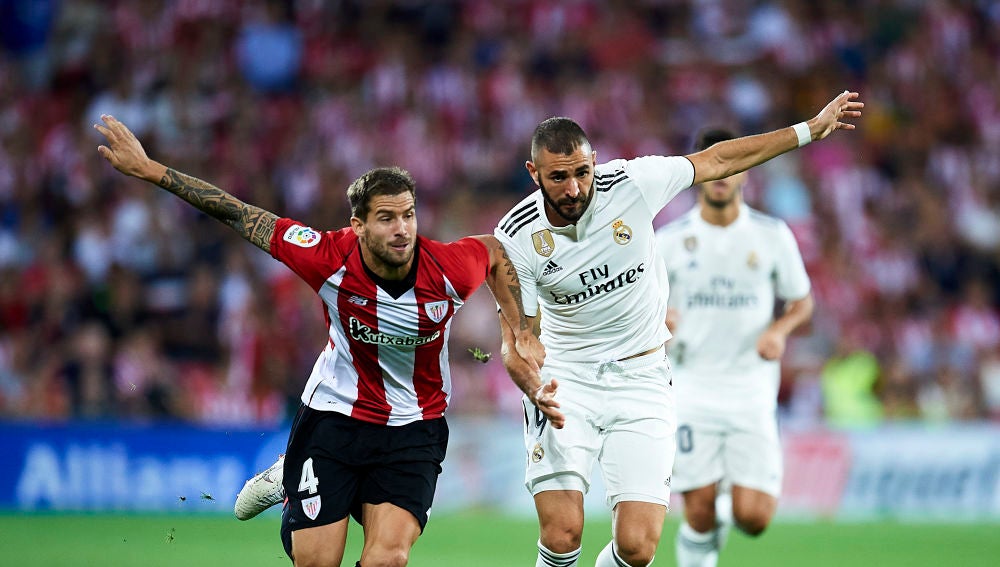 Iñigo Martínez y Benzema se disputan la posesión del balón
