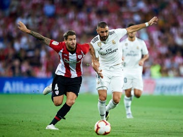 Iñigo Martínez y Benzema se disputan la posesión del balón