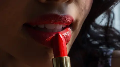 Mujer aplicándose pintalabios Mujer aplicándose pintalabios