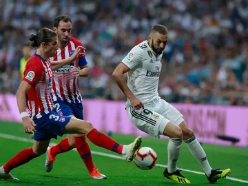 Benzema intenta zafarse de Filipe Luis y Godín Benzema intenta zafarse de Filipe Luis y Godín