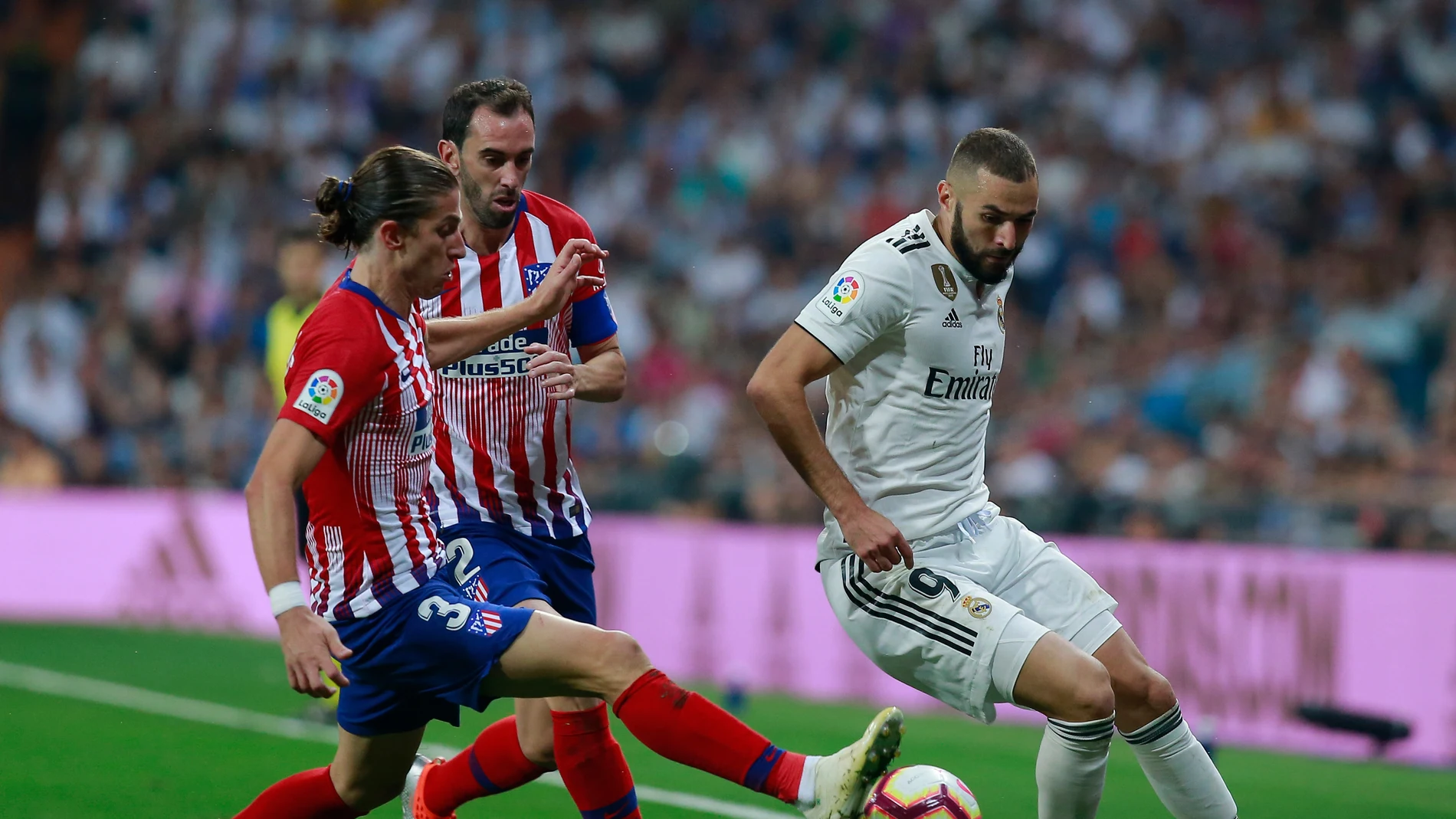 Benzema intenta zafarse de Filipe Luis y Godín Benzema intenta zafarse de Filipe Luis y Godín
