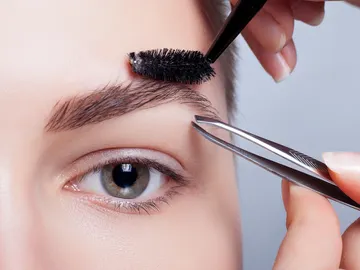 Mujer se depila las cejas Mujer se depila las cejas