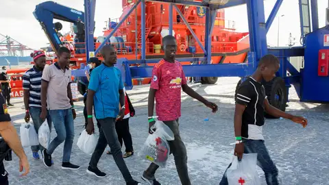 Varios inmigrantes salen de la embarcacíon para subir a un autobús que los llevará a San Roque Varios inmigrantes salen de la embarcacíon para subir a un autobús que los llevará a San Roque