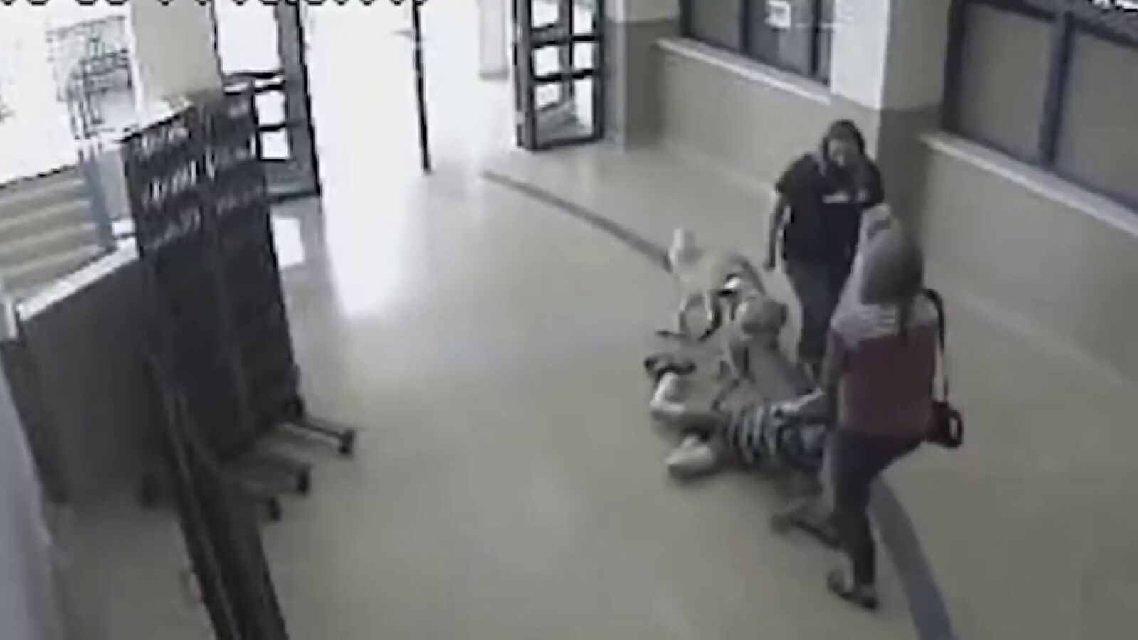 Una profesora y una enfermera de una escuela arrastran por el pasillo a un niño autista y a su perro guía